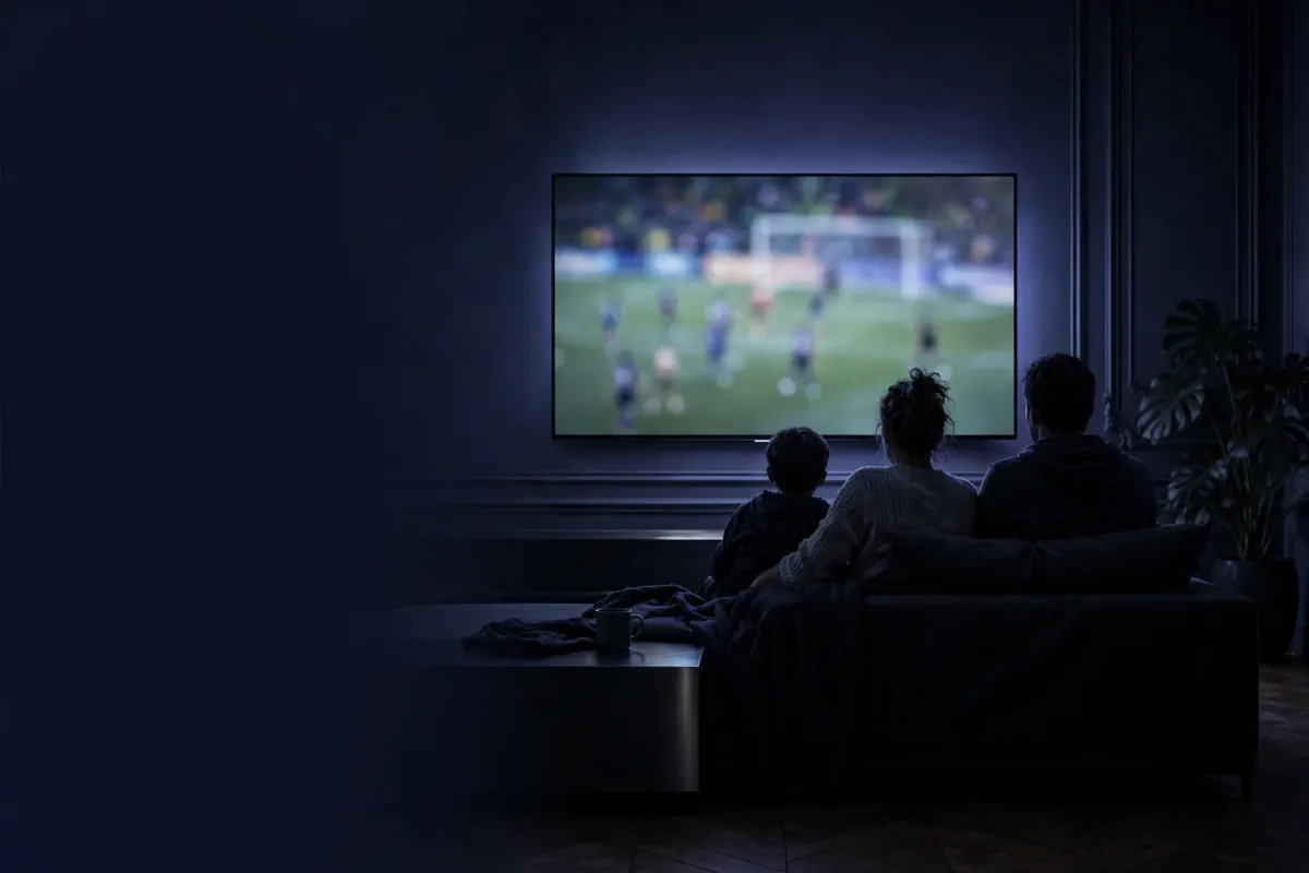 Famille devant une TV dans un salon français, écran affichant un match de football générique